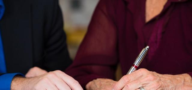 An older couple signing documents