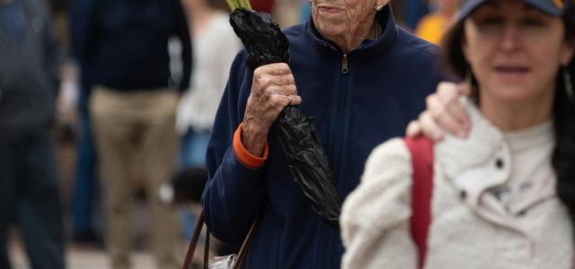 A man holding a bouquet of sunflowers while walking down a street by Joseph Corl courtesy of Unsplash.