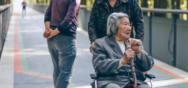 woman sitting on wheelchair by Raychan courtesy of Unsplash.
